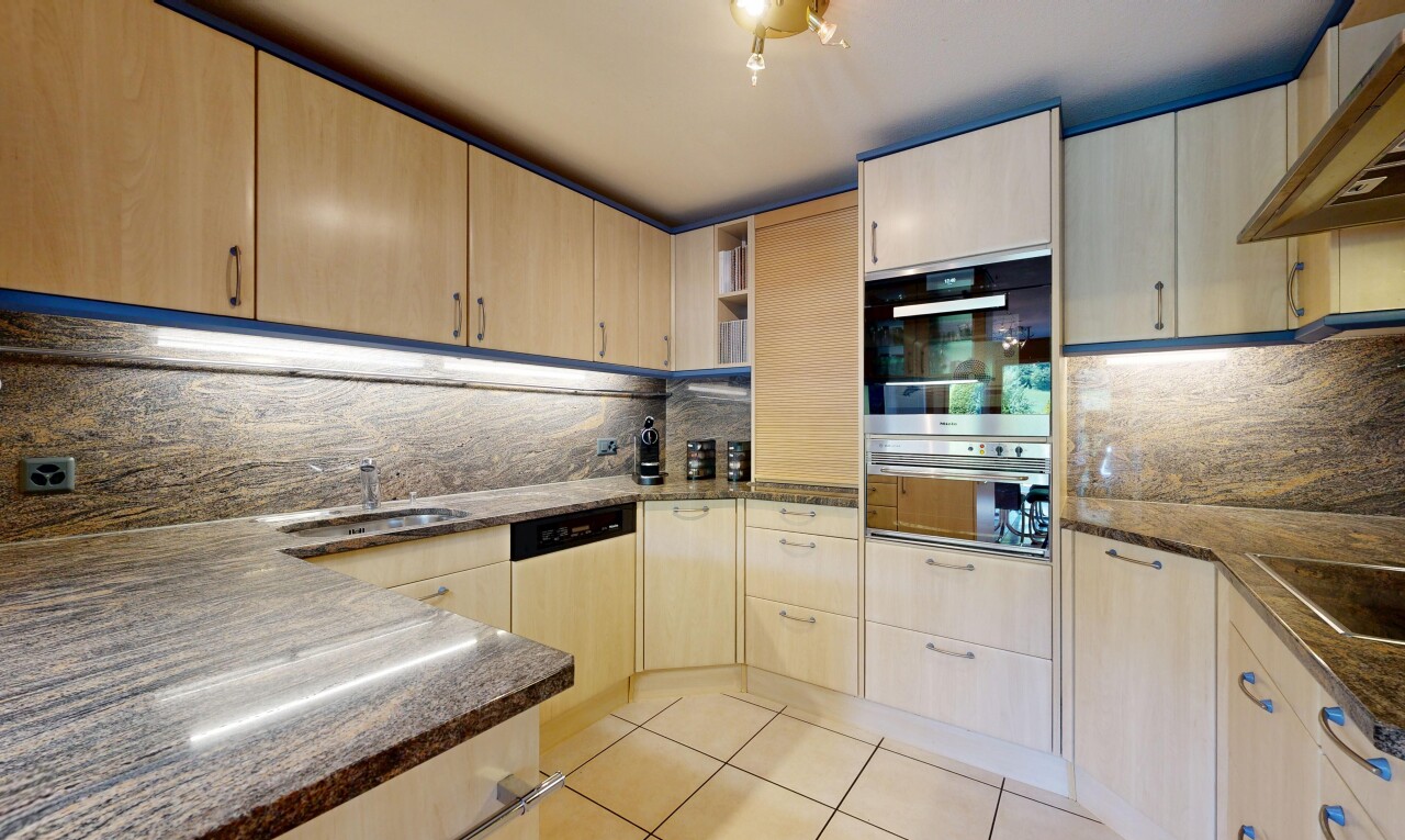 küche mit dark countertops, hellbraune schränke, light brown cabinets, light floor, und küchenrückwand beim Herd