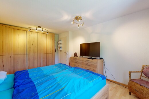 zimmer / schlafzimmer mit fernseher, inside property, gipskartonwand, drywall, und holzfußboden