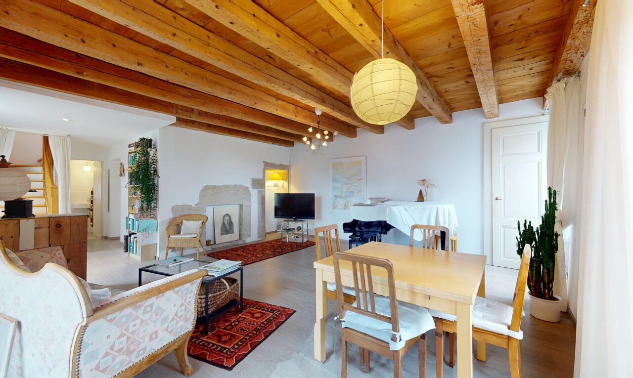 salon / salle à manger avec beamed ceiling, plafond à poutres, inside property, télévision, et drywall