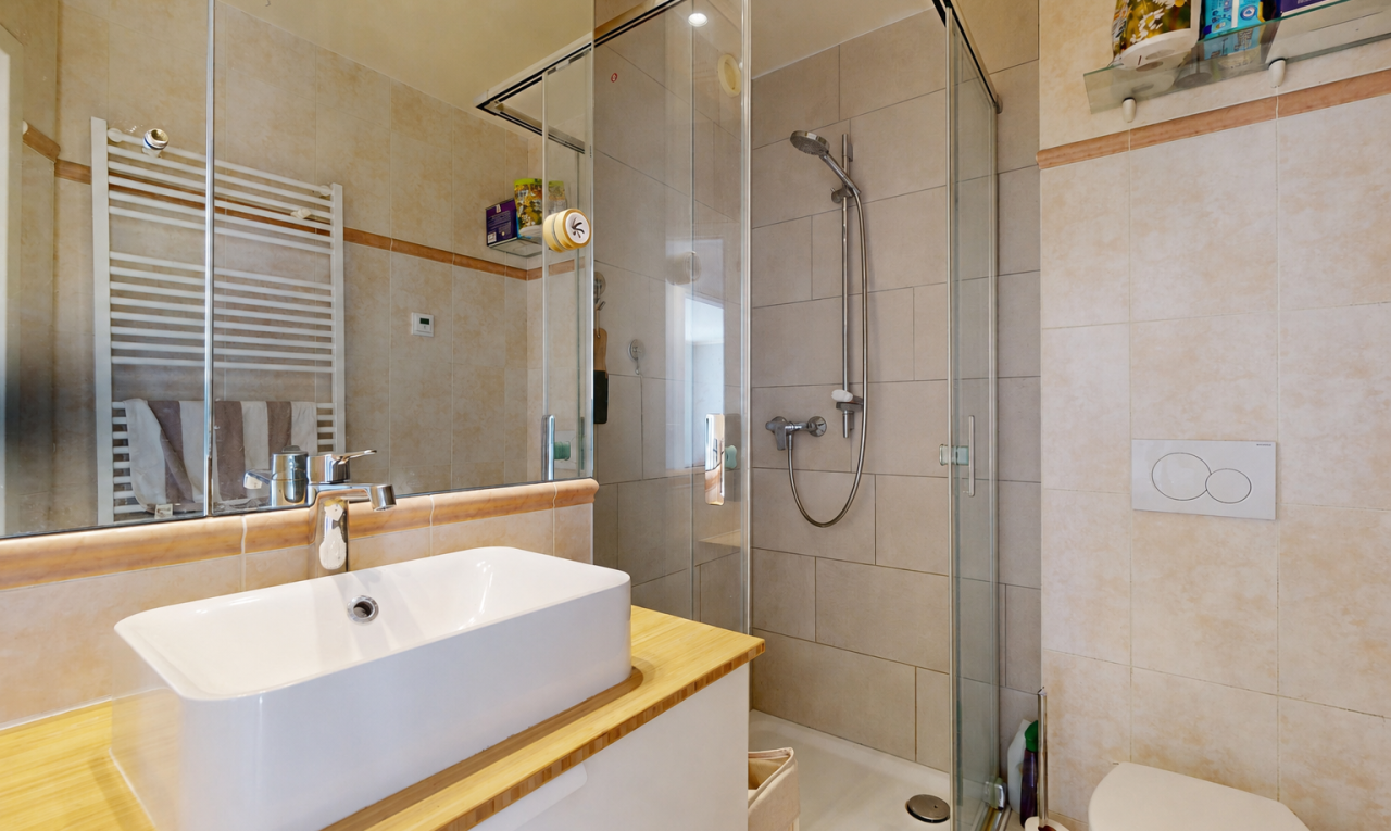 salle de bains avec mur en carrelage, tile wall, lavabo (ou coiffeuse selon le contexte), salle de bain complète, et douche