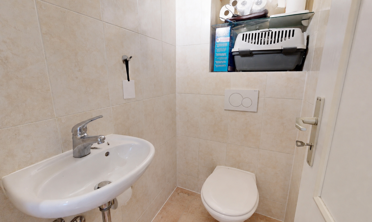salle de bains avec toilette, inside property, mur en carrelage, tile wall, et évier