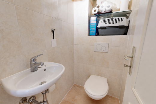 salle de bains avec toilette, inside property, mur en carrelage, tile wall, et évier