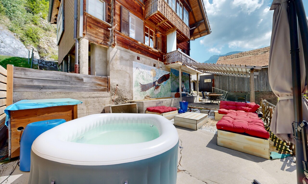 piscine avec bain à remous, clôture, terrasse, espace de vie extérieur, et day time
