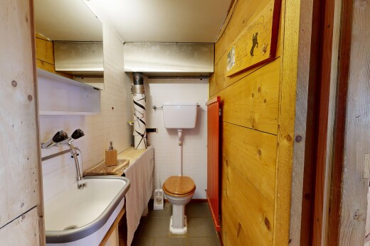 half bath featuring a sink and dark tile patterned flooring