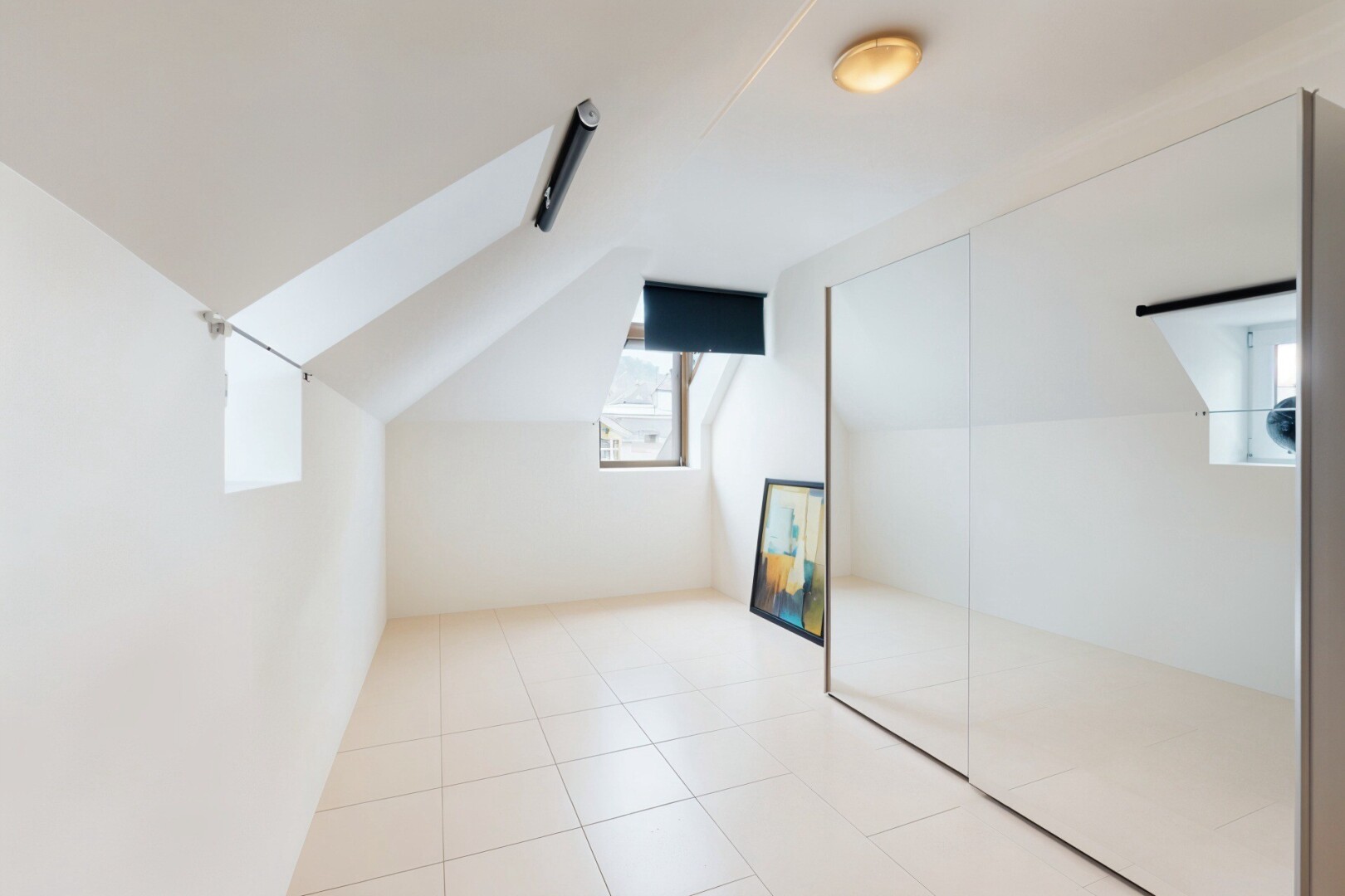 pièce vide avec natural light, lumière naturelle, vaulted ceiling, plafond voûté, et tile floor