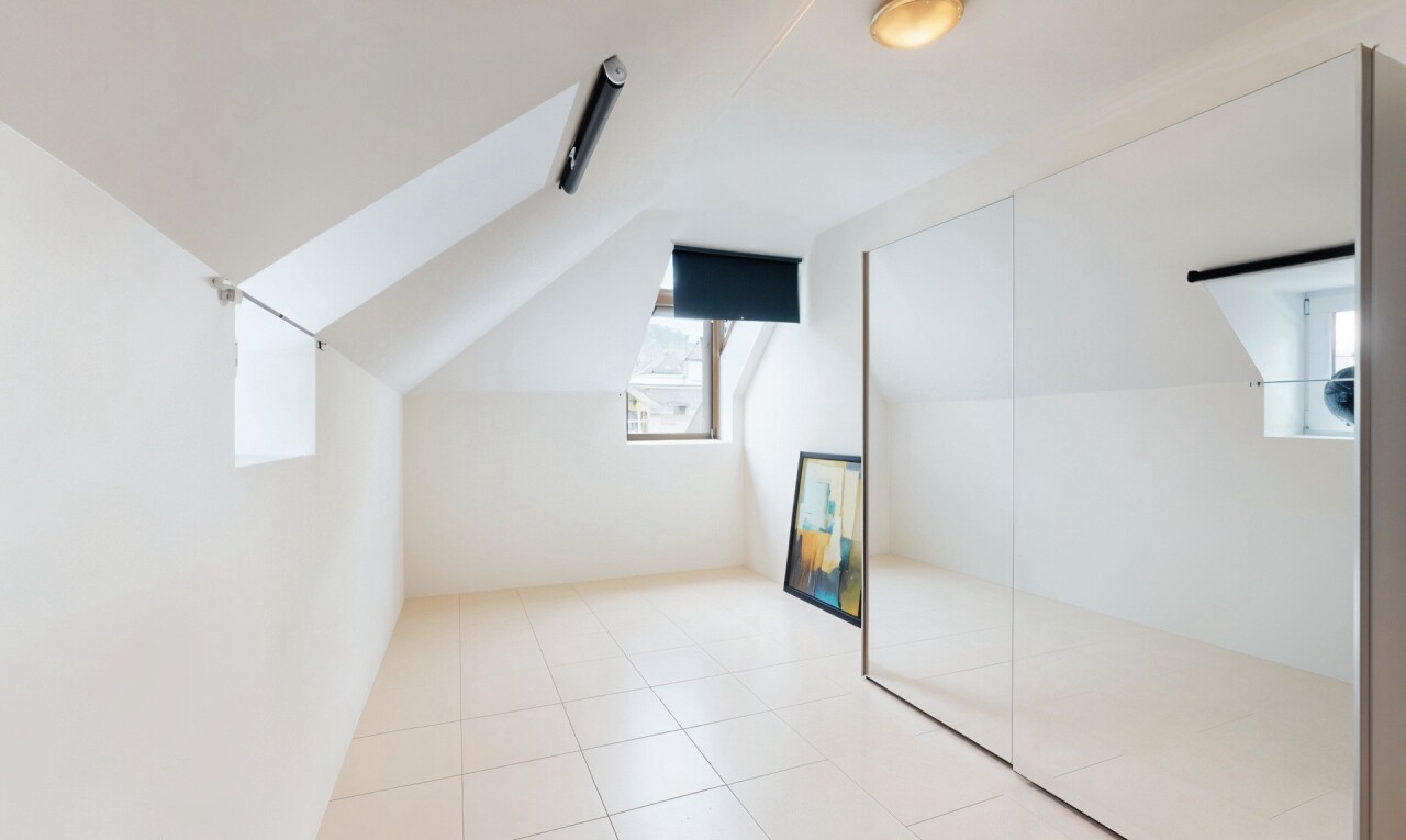 pièce vide avec natural light, lumière naturelle, vaulted ceiling, plafond voûté, et tile floor