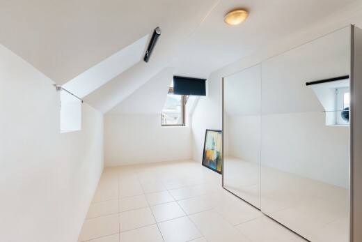 leerer raum mit natural light, natürliches licht, vaulted ceiling, dachschräge, und tile floor