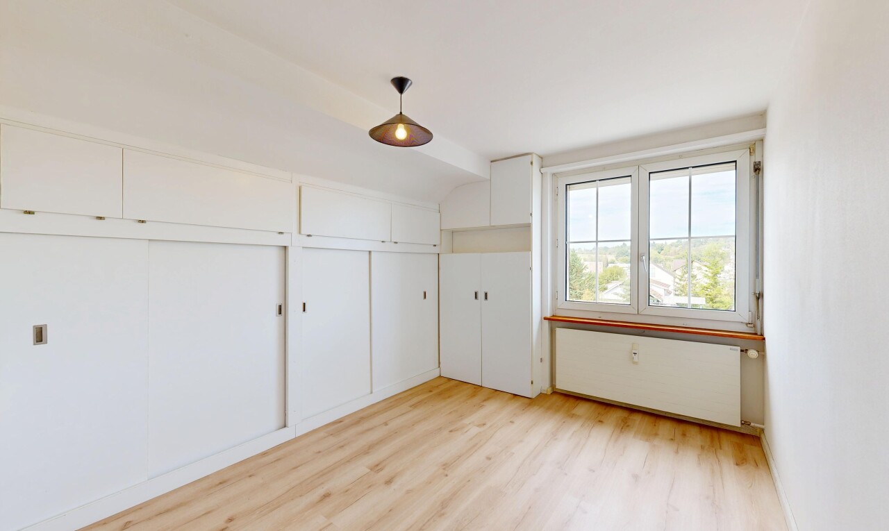 empty room featuring light wood-style flooring and hanging light fixtures
