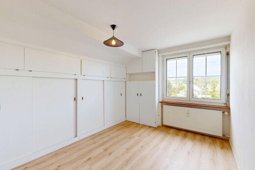 empty room featuring light wood-style flooring and hanging light fixtures
