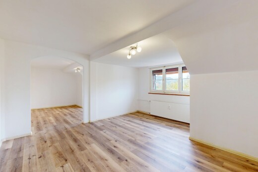 unfurnished room with light wood finished floors and arched walkways