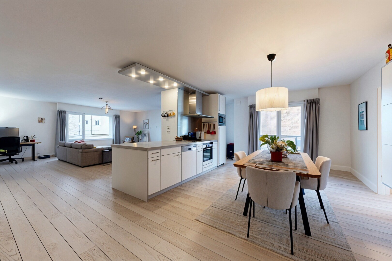 kitchen featuring white cabinets, light countertops, light wood-type flooring, and open floor plan