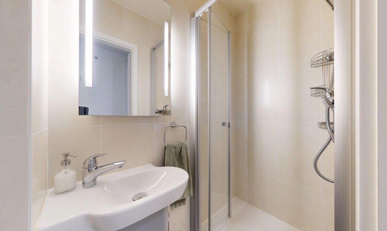 full bathroom with a stall shower, tile walls, vanity, and tasteful backsplash