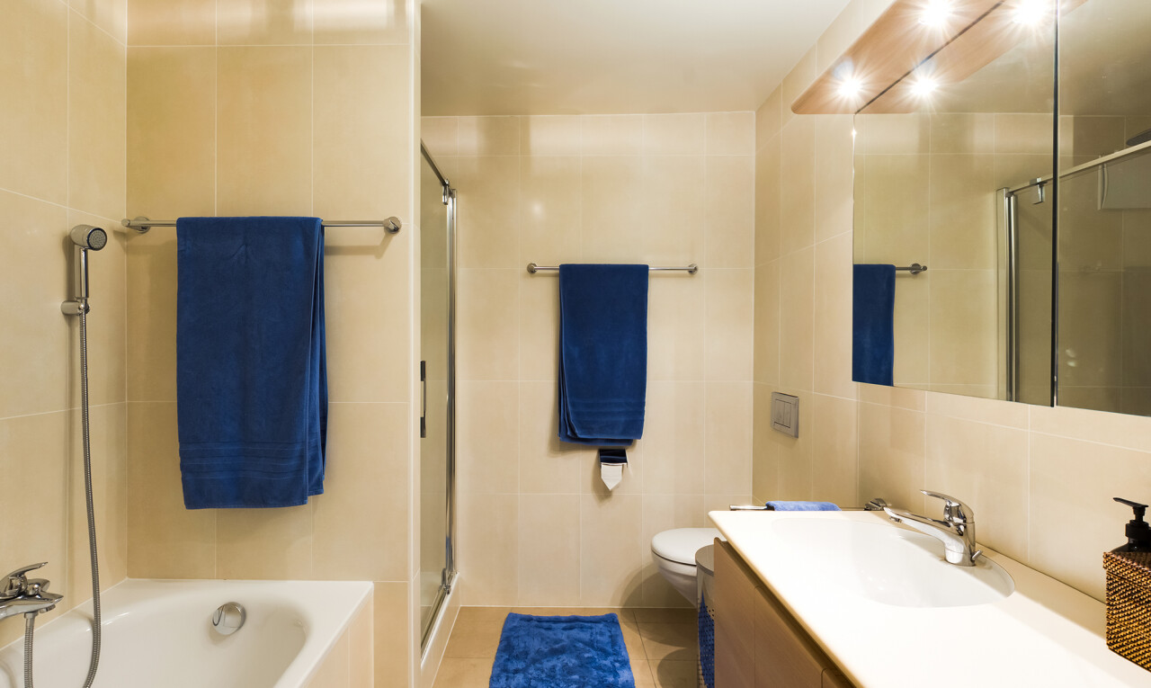 salle de bains avec lavabo (ou coiffeuse selon le contexte), tile wall, mur en carrelage, douche, et salle de bain complète