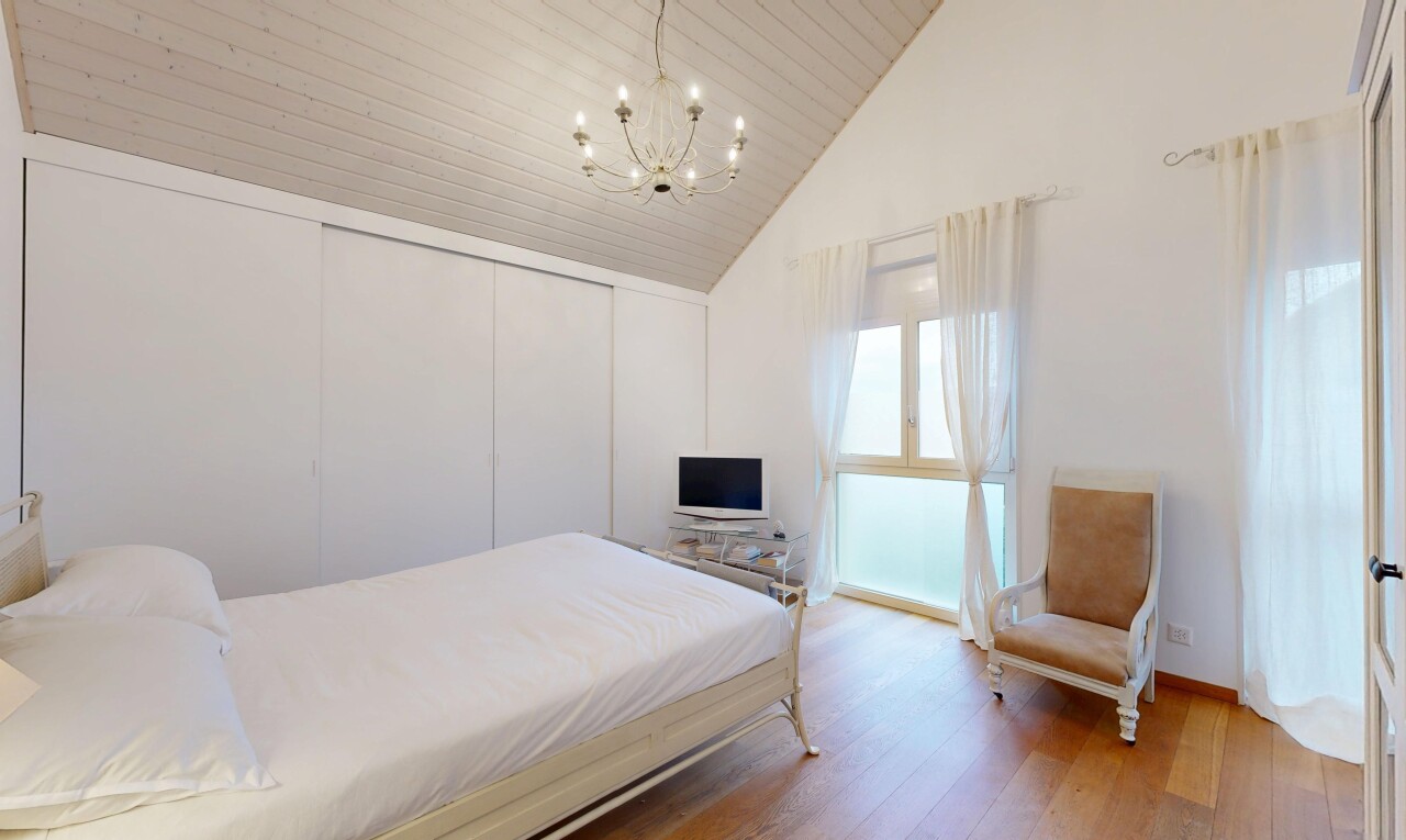 chambre avec inside property, lustre remarquable, lumière naturelle, natural light, et sol en finition bois