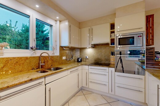 kitchen with oven, light stone counters, tasteful backsplash, light tile patterned floors, and white cabinets