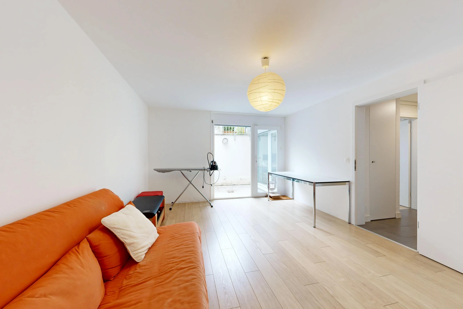 salon avec cloison sèche, drywall, accès à l'extérieur, sol en finition bois, et wood finish floor