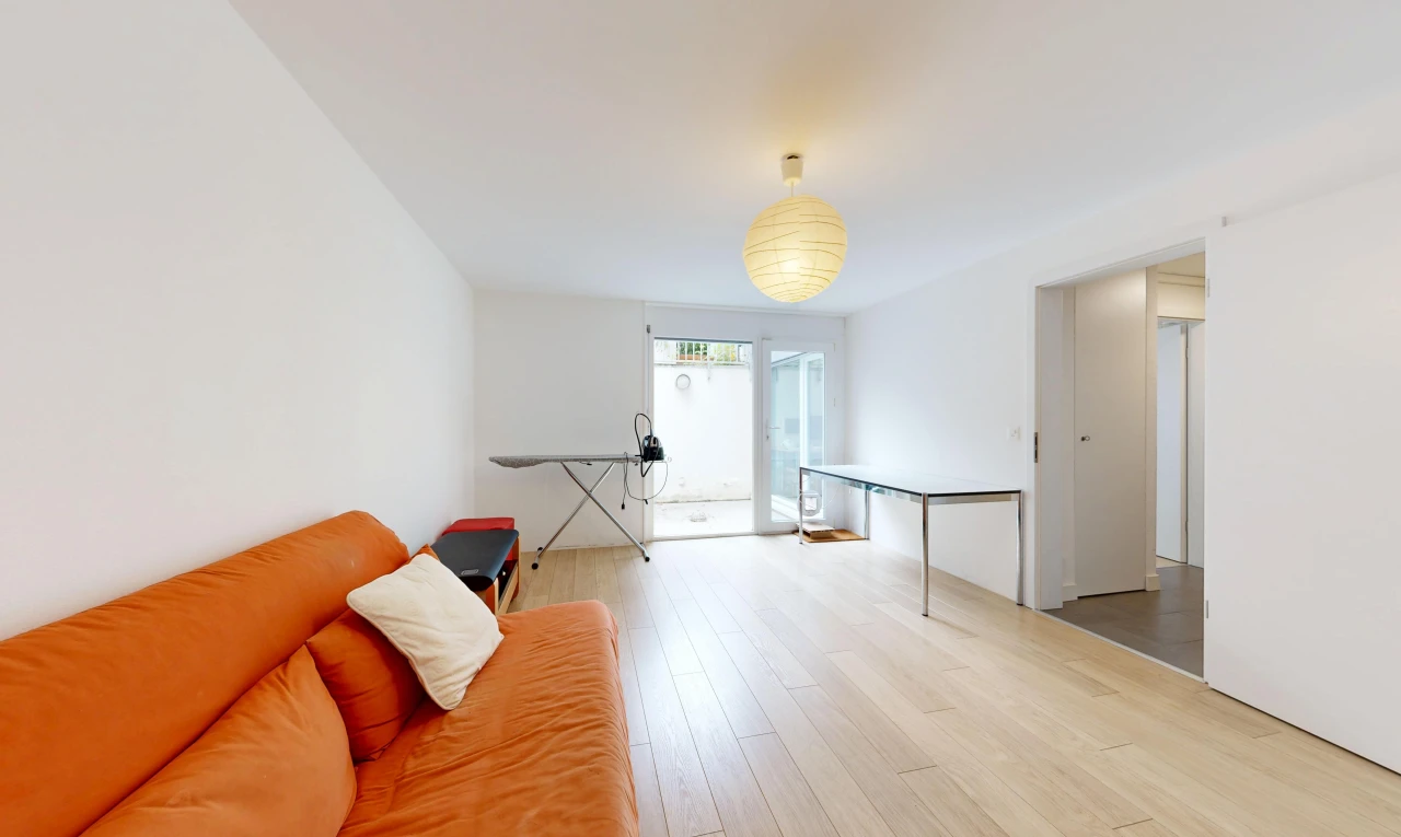 salon avec cloison sèche, drywall, accès à l'extérieur, sol en finition bois, et wood finish floor