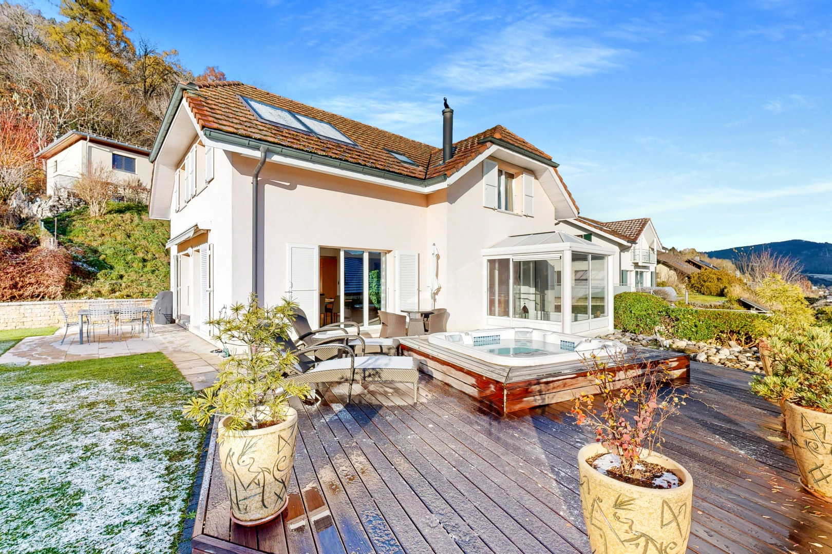 façade avec solarium, jacuzzi, et terrasse en bois