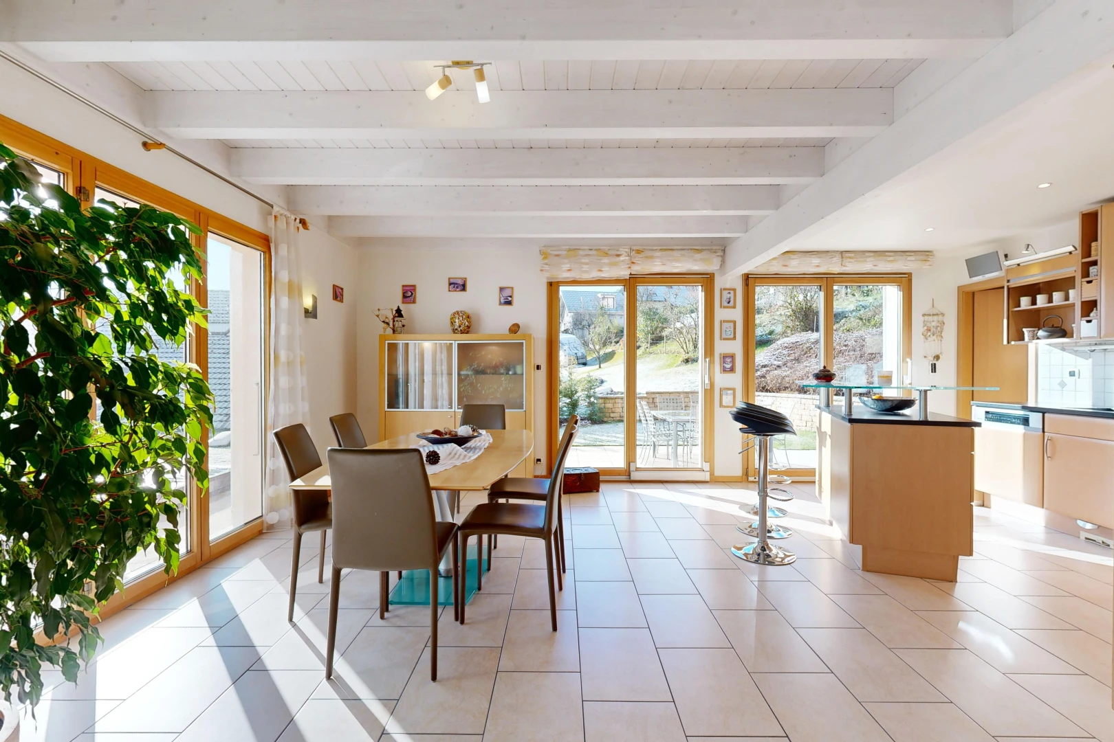 salle à manger avec carrelage, poutres apparentes, et lumière naturelle