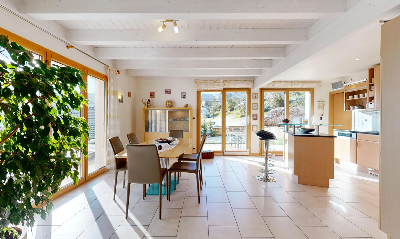 salle à manger avec carrelage, poutres apparentes, et lumière naturelle