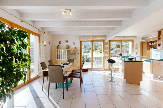 salle à manger avec carrelage, poutres apparentes, et lumière naturelle