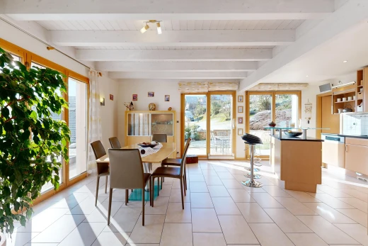 salle à manger avec carrelage, poutres apparentes, et lumière naturelle