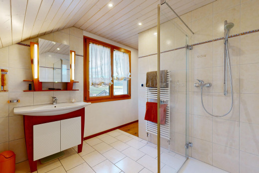 salle de bains avec radiateur, plafond voûté, meuble-lavabo, lumière naturelle, et miroir