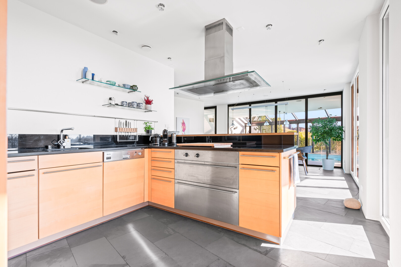cuisine avec plans de travail, dark countertops, armoires marron clair, light brown cabinets, et péninsule de cuisine