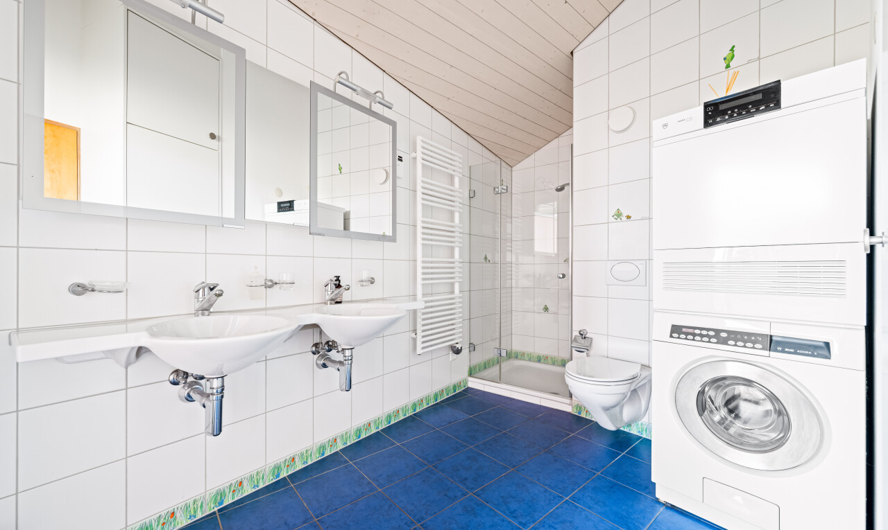 salle de bains avec mur en carrelage, tile wall, miroir, chauffe-serviettes, et radiateur