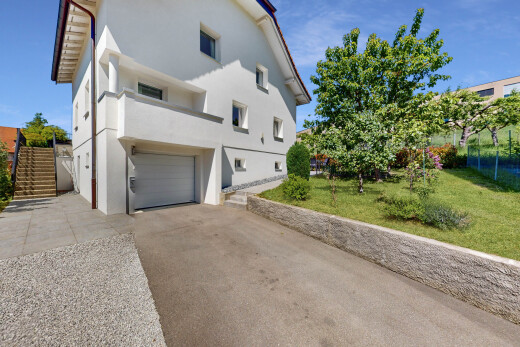 außenansicht mit stuckverkleidung, day time, auffahrt, eingebaute garage, und rasen