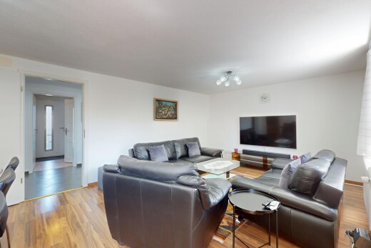 wohnzimmer mit fernseher, gipskartonwand, drywall, inside property, und holzfußboden