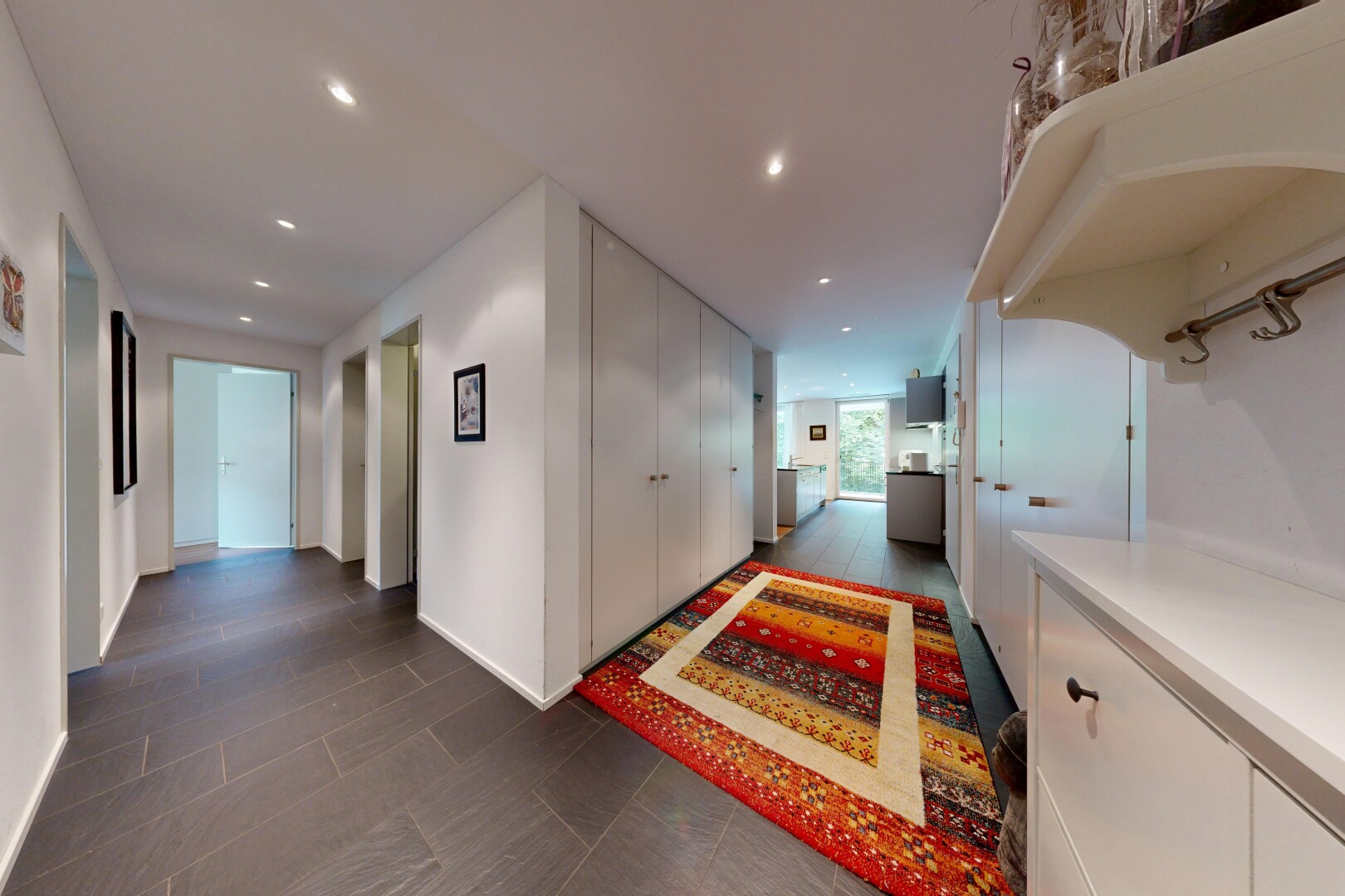 couloir avec éclairage encastré, cloison sèche, drywall, dark floor, et inside property