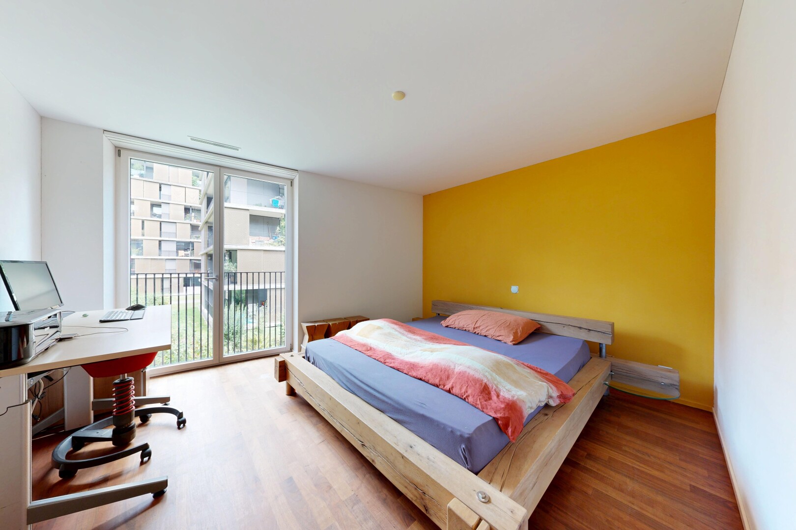 chambre avec cloison sèche, drywall, accès à l'extérieur, sol en finition bois, et wood finish floor