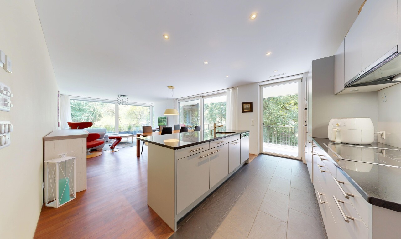 cuisine avec dark countertops, éclairage encastré, îlot de cuisine, kitchen island, et évier