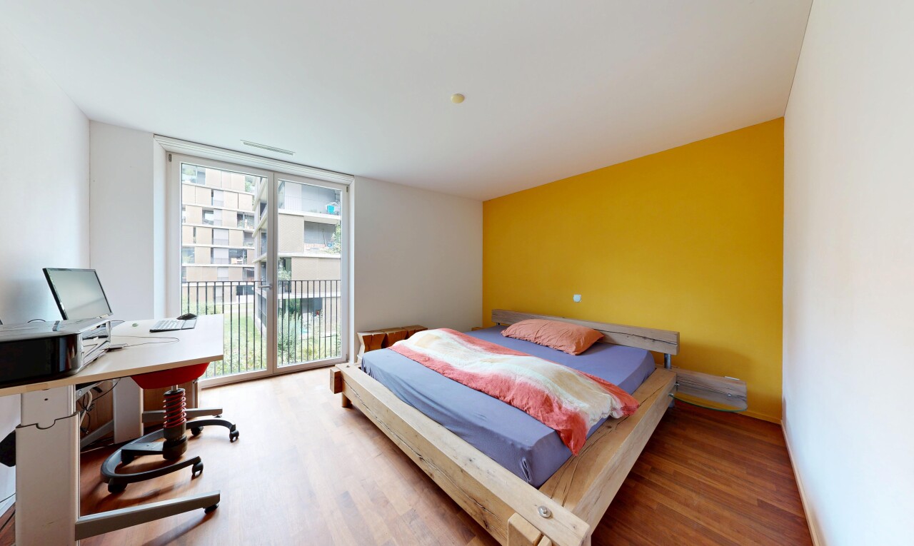 chambre avec cloison sèche, drywall, accès à l'extérieur, sol en finition bois, et wood finish floor