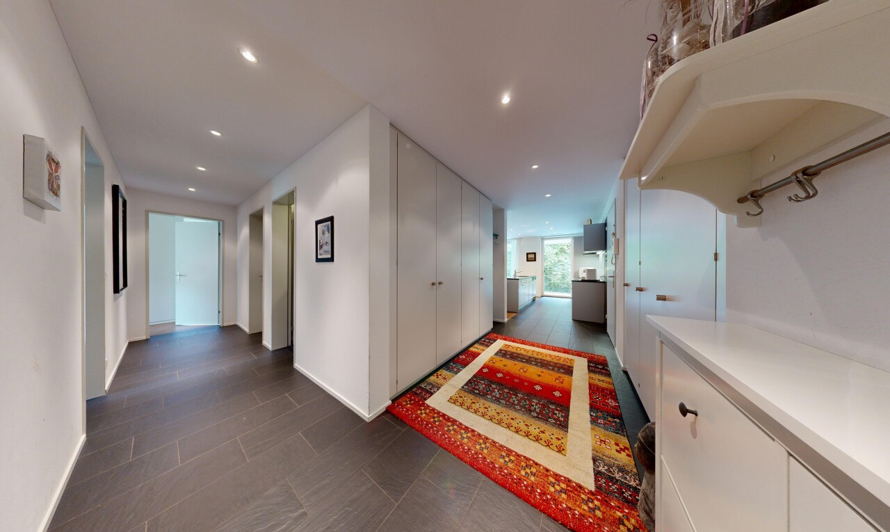 couloir avec éclairage encastré, cloison sèche, drywall, dark floor, et inside property