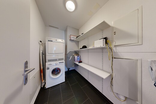 buanderie avec lave-linge et sèche-linge superposés, dark floor, cloison sèche, drywall, et inside property