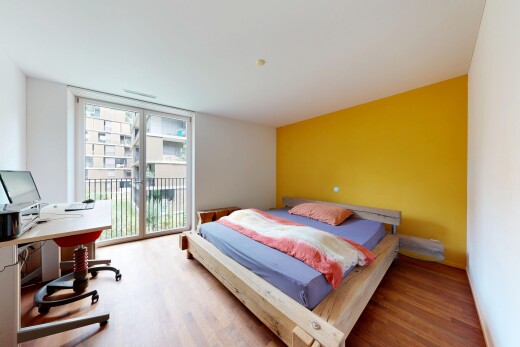 chambre avec cloison sèche, drywall, accès à l'extérieur, sol en finition bois, et wood finish floor