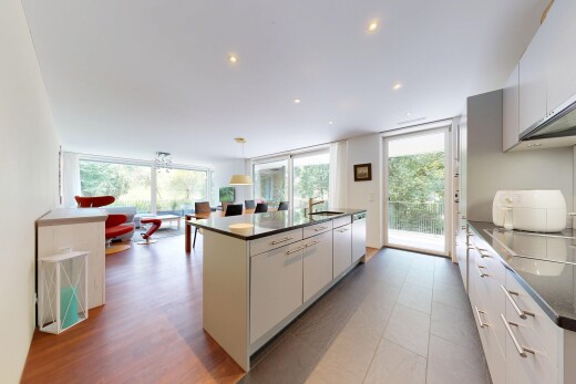 cuisine avec dark countertops, éclairage encastré, îlot de cuisine, kitchen island, et évier