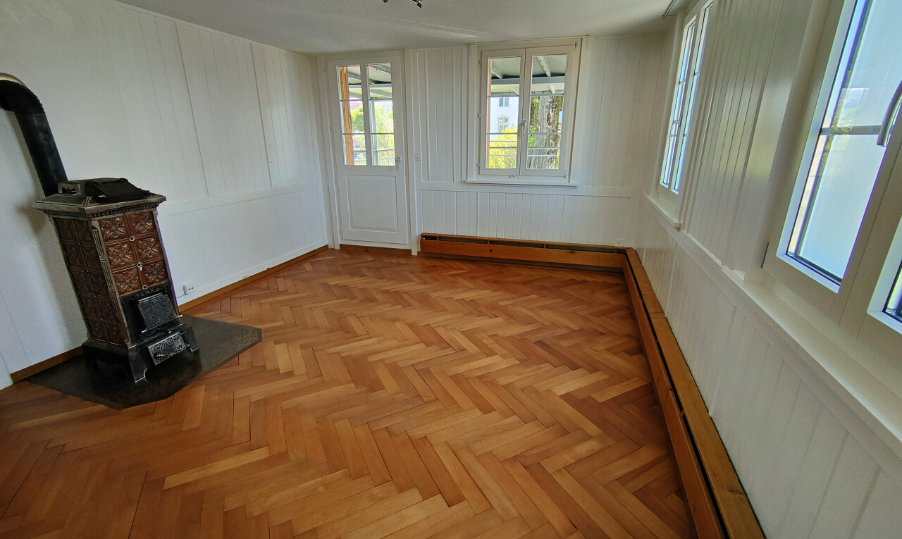 pièce vide avec parquet floor, radiateur à plinthe, wood finish floor, sol en finition bois, et paneling wall