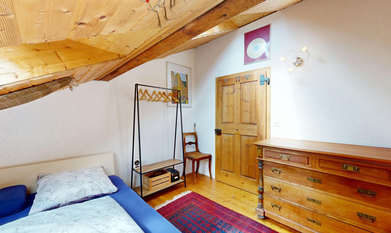 chambre avec wood finish floor, sol en finition bois, drywall, cloison sèche, et vaulted ceiling