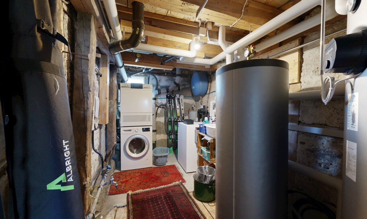 buanderie avec buanderie, chauffe-eau, sous-sol, lave-linge et sèche-linge superposés, et inside property