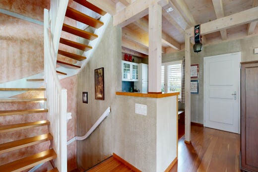 stairs featuring wood-type flooring and beam ceiling