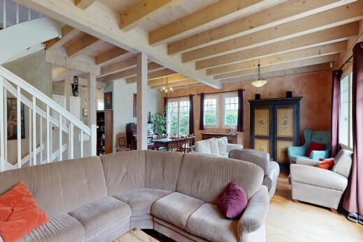 living room featuring healthy amount of natural light, beamed ceiling, a chandelier, and wood finished floors