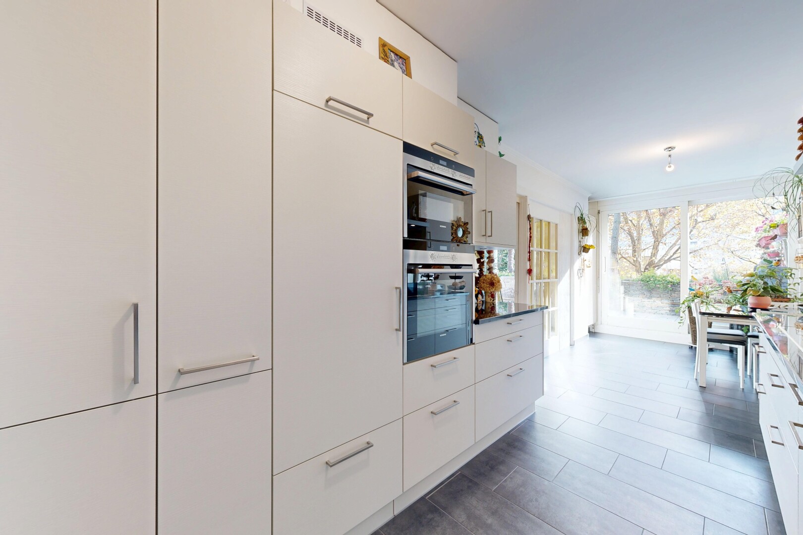 küche mit natural light, natürliches licht, weiße schränke, schränke mit flachen paneelen, und inside property