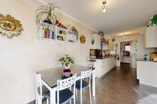 cuisine avec cuisine en couloir, armoires blanches, inside property, plans de travail, et lumière naturelle