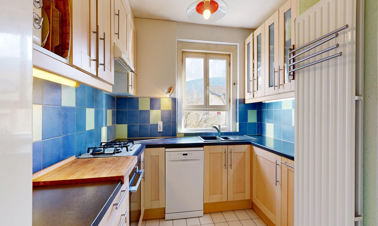 cuisine avec armoires avec insert en verre, glass insert cabinets, light floor, dark countertops, et lave-vaisselle