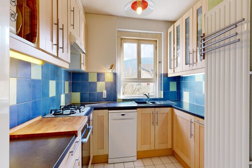 cuisine avec armoires avec insert en verre, glass insert cabinets, light floor, dark countertops, et lave-vaisselle