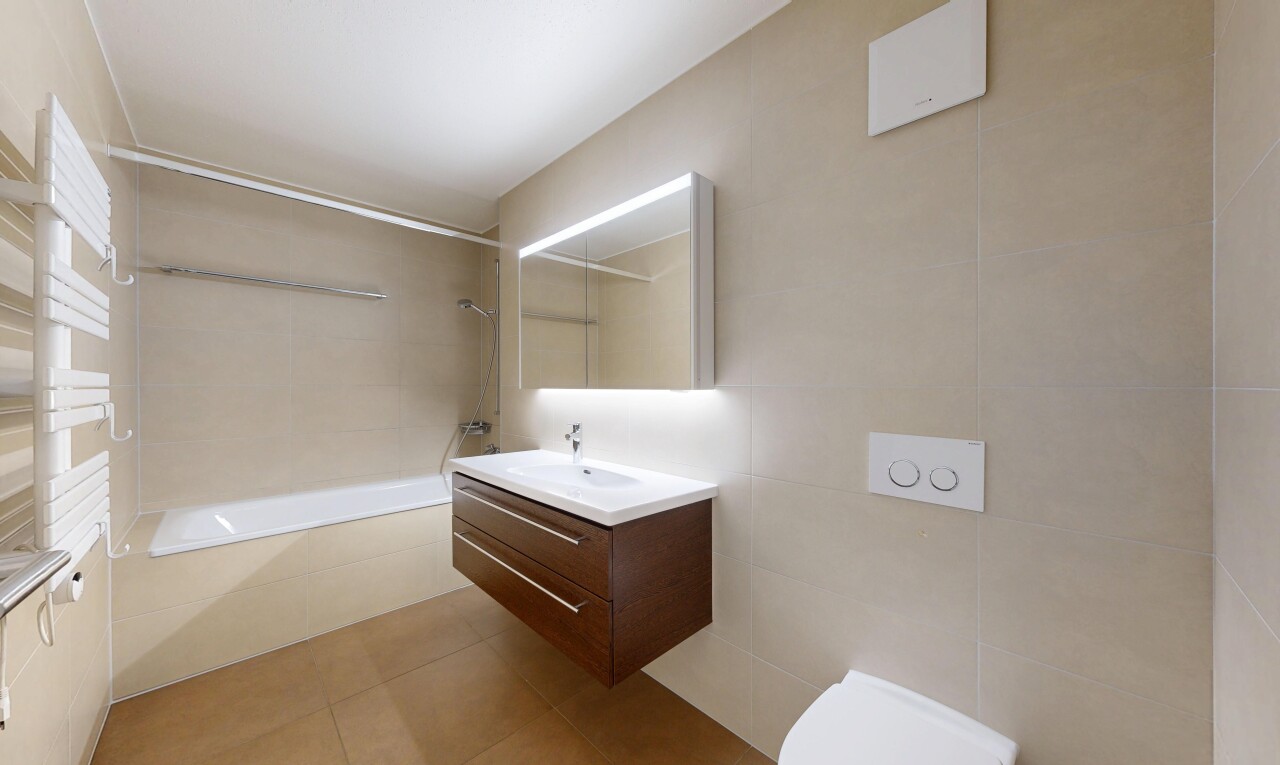 full bathroom with tile walls, vanity, light tile patterned flooring, and tiled shower / bath combo