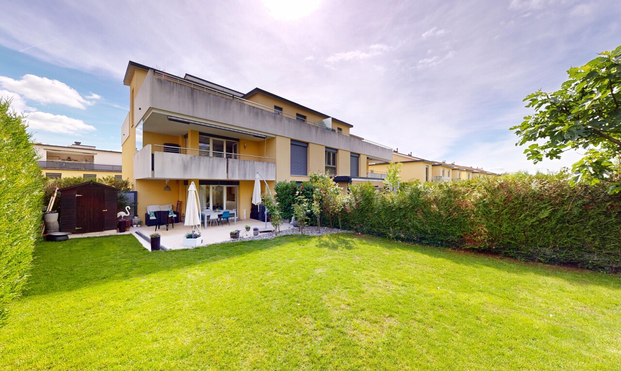 view of property featuring a balcony, a patio area, a lawn, and stucco siding